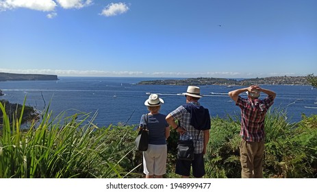 Happy Retirement Concept. Scenic Sydney Sea View. Senior Diverse Couple Sitting On A White Couch In Beach House. Authentic Senior Retired Life Concept. Plan Life Insurance At Retirement Concept.