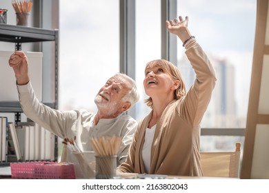 Happy Retirement Concepts, Portrait Of Senior Couple Painting On A Canvas In Living Room, Older Man And Woman Drawing Together On A Canvas At Art Studio