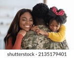 Happy Reunion. Joyful Wife And Daughter Hugging Military Man, Welcoming Him After Returning Home From Army, Male Soldier In Camouflage Uniform Embracing With Family, Closeup Shot With Free Space