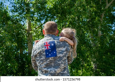 Happy Reunion Of Soldier From Australia With Family, Daughter Hug Father. A Little Girl Holds The Flag Of Australia In Her Hand