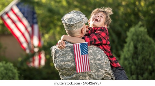 Happy Reunion Of Soldier With Family Outdoors. Father With His Son Hugging, Holiday, Homecoming, Emotions, Happiness