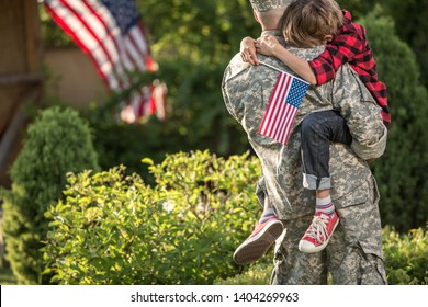 Happy Reunion Of Soldier With Family Outdoors. Father With His Son Hugging, Holiday, Homecoming, Emotions, Happiness