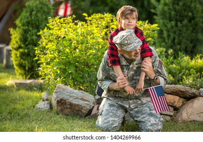 Happy Reunion Of Soldier With Family Outdoors. Father With His Son Hugging, Holiday, Homecoming, Emotions, Happiness