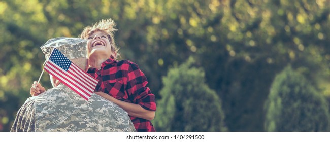 Happy Reunion Of Soldier With Family Outdoors. Father With His Son Hugging, Holiday, Homecoming, Emotions, Happiness