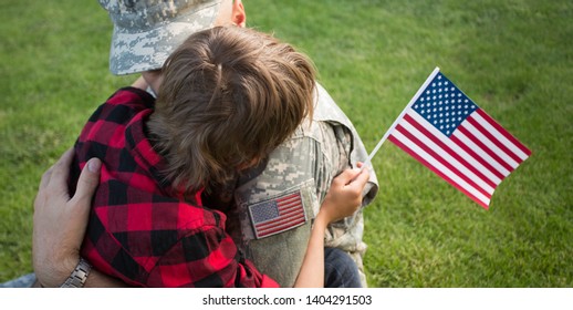 Happy Reunion Of Soldier With Family Outdoors. Father With His Son Hugging, Holiday, Homecoming, Emotions, Happiness