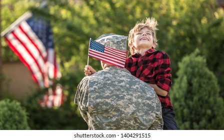 Happy Reunion Of Soldier With Family Outdoors. Father With His Son Hugging, Holiday, Homecoming, Emotions, Happiness