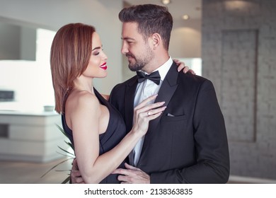 Happy Rich 30s Woman Holding Sexy Boyfriend In Tuxedo