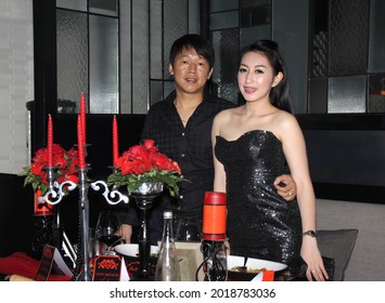 
Happy Rich Asian Couple In Black Dress Posing At Candle Light Dinner Decoration Table. Jakarta March 16, 2016