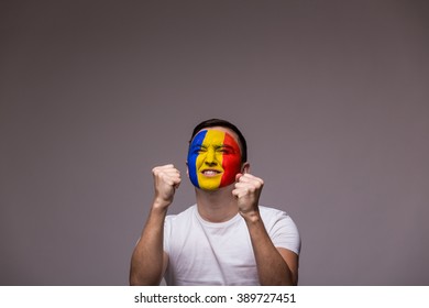 Happy Romanian Football Fan In Game  Support Of Romania National Team On Grey Background. European Football Fans Concept.