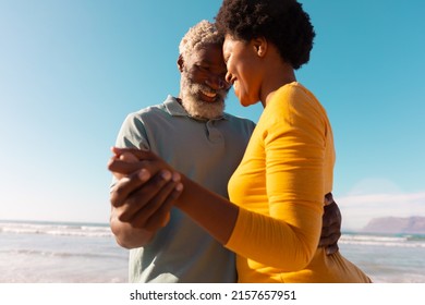 Happy romantic african american couple dancing at beach against clear blue sky on sunny day. - Powered by Shutterstock