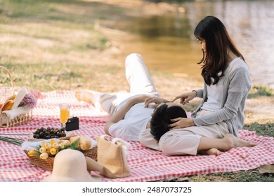 Happy romantic asian couple lying down at the park picnic time in summer holidays vacation - Powered by Shutterstock