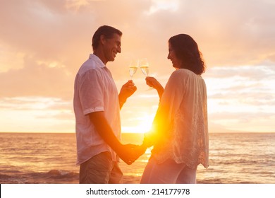 Happy Romantic Couple Enjoying Glass of Champagne at Sunset on the Beach. Vacation Travel Retirement Anniversary Celebration. - Powered by Shutterstock