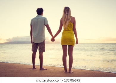 Happy Romantic Couple Watching the Sunset Holding Hands on Tropical Beach Vacation, Vintage Trendy Color Styling