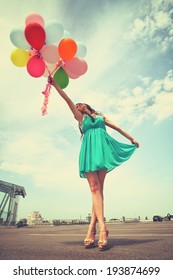 Happy romantic fashion girl with colorful balloons, outdoors. Toned.