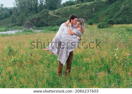Happy romantic inloved couple looking at each other on a field outdoors.