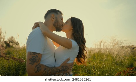 Happy romantic loving Caucasian couple man woman tender family wife husband kiss guy hug girl showing love hugging embracing kissing outdoors deserted wheat field sunrise sunshine dating relationship - Powered by Shutterstock