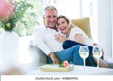 Happy romantic mature couple sitting on armchair at home - Powered by Shutterstock