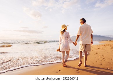 Happy Romantic Middle Aged Couple Enjoying Beautiful Sunset Walk on the Beach. Travel Vacation Retirement Lifestyle Concept - Shutterstock ID 352166342