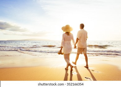 Happy Romantic Middle Aged Couple Enjoying Beautiful Sunset Walk on the Beach. Travel Vacation Retirement Lifestyle Concept