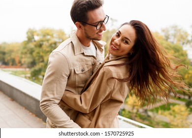 Happy romantic moments of lovely couple dancing and fooling around in park during dating. 
