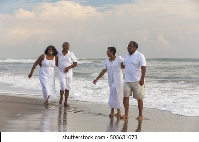 Happy romantic senior African American men and women couples laughing, walking, holding hands on a deserted tropical beach 