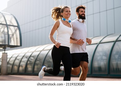 Happy Runner Couple Exercising Outside As Part Of Healthy Lifestyle. People Sport Running Concept