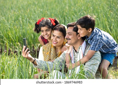 Happy Rural Farmer Taking Selfie With Family Using Mobile Phone On Agriculture Field