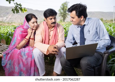 Happy Rural Indian Farmer Family With Agronomist Or Banker Use Laptop. Man Officer Showing Policy On Computer Screen, Financial Support Or Farming Crop Loan,  Husband Wife With Government Scheme Agent