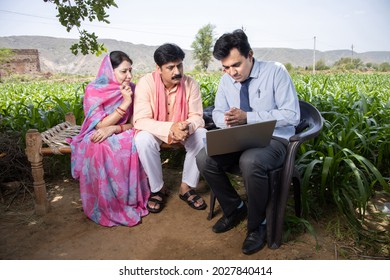 Happy Rural Indian Farmer Family With Agronomist Or Banker Use Laptop. Man Officer Showing Policy On Computer Screen, Financial Support Or Farming Crop Loan,  Husband Wife With Government Scheme Agent