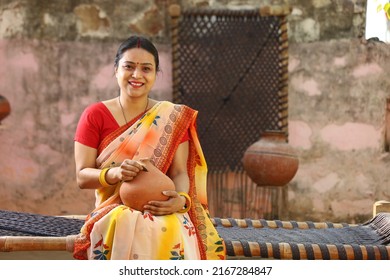 Happy Rural Indian Women In Saree  With The Piggy Bank In Hand. Aspirational Woman Showing Her Love Towards Their Money Saved And Showing Different Expressions And Emotions Of Life.