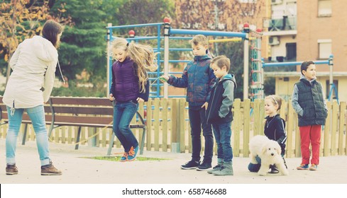 happy russian children playing rubber band jumping game and laughing outdoors