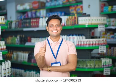Happy salesman show thumbs up at grocery store products