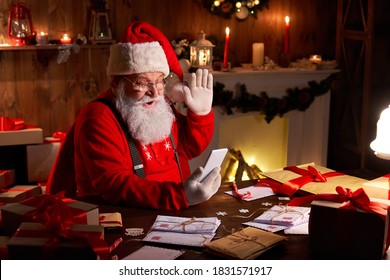 Happy Santa Claus holding smartphone video calling kid talking to child in virtual video online chat meeting sit at home table late with presents on xmas eve. Merry Christmas social distance concept. - Powered by Shutterstock