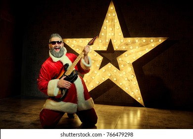 Happy Santa with a guitar is dancing against the background of a - Powered by Shutterstock