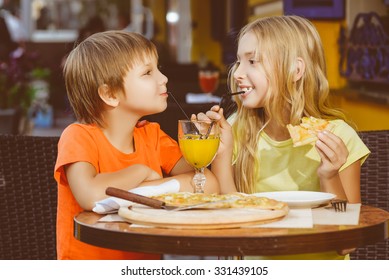 Happy Or Satisfied Boy Width Girl Eating Pizza And Drinking Juice