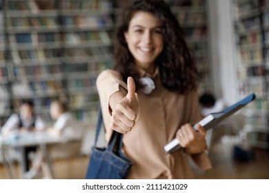 Happy satisfied college girl making thumb up, showing like hand sign at camera. Close up of hand. Successful graduate student recommending college, university education, study courses