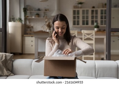 Happy Satisfied Internet Shop Customer Girl Unwrapping Parcel At Home, Making Telephone Call To Contact Center, Talking On Mobile Phone, Thanking Sender For Gift, Sharing Positive Feedback