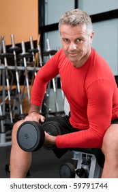 Happy Satisfied Mature Man Lifting Weights At Gym