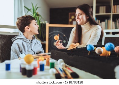 Happy School Boy And Girl  Making A Solar System For A School Science Project At Home