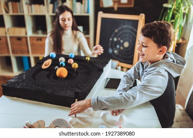 Happy School Boy And Girl  Making A Solar System For A School Science Project At Home