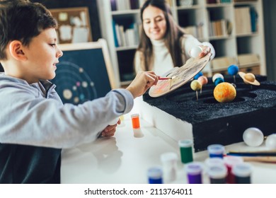 Happy School Boy And Girl  Making A Solar System For A School Science Project At Home