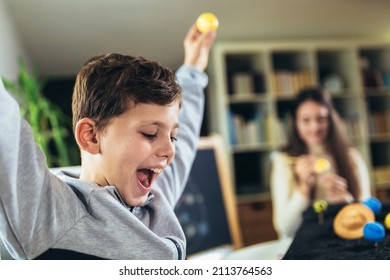 Happy School Boy And Girl  Making A Solar System For A School Science Project At Home