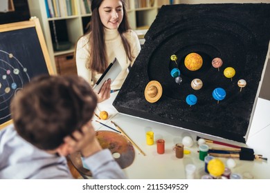 Happy School Boy And Girl  Making A Solar System For A School Science Project At Home