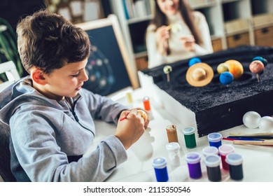 Happy School Boy And Girl  Making A Solar System For A School Science Project At Home