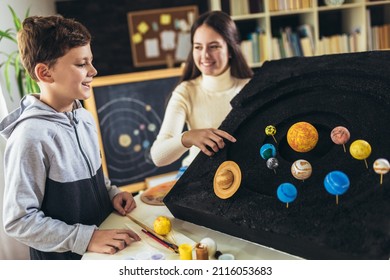 Happy School Boy And Girl  Making A Solar System For A School Science Project At Home