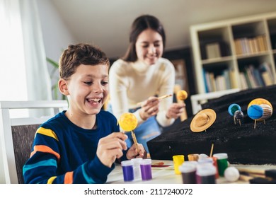 Happy School Boy And Girl  Making A Solar System For A School Science Project At Home