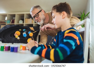 Happy School Boy And His Father Making A Solar System For A School Science Project At Home