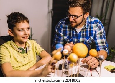 Happy School Boy And His Father Making A Solar System For A School Science Project At Home