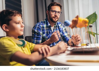 Happy School Boy And His Father Making A Solar System For A School Science Project At Home