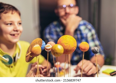 Happy School Boy And His Father Making A Solar System For A School Science Project At Home